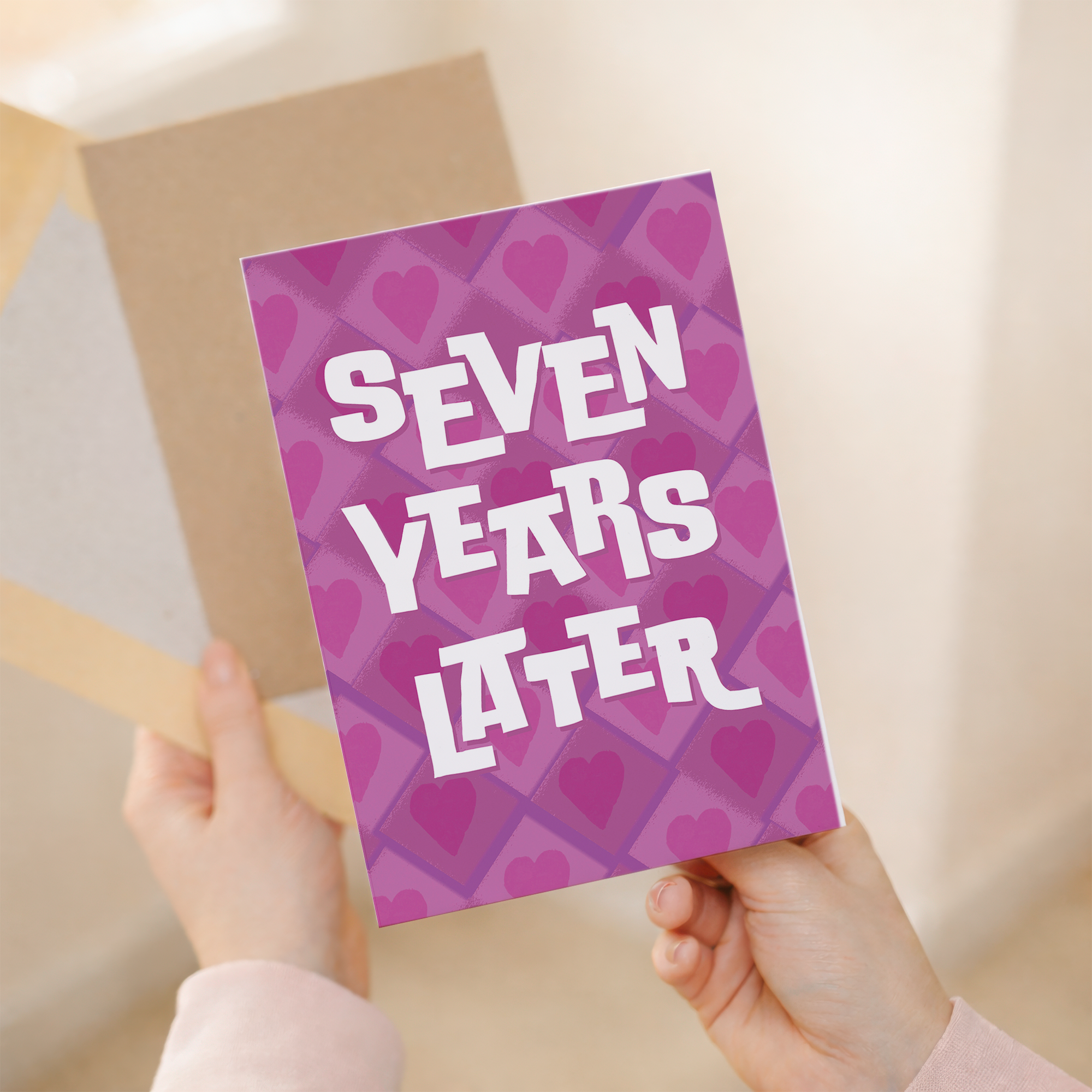 Elegant 7th Wedding Anniversary greeting card featuring a modern design in pink, white, and purple on sustainable recycled cardstock, paired with a classic brown Kraft envelope.