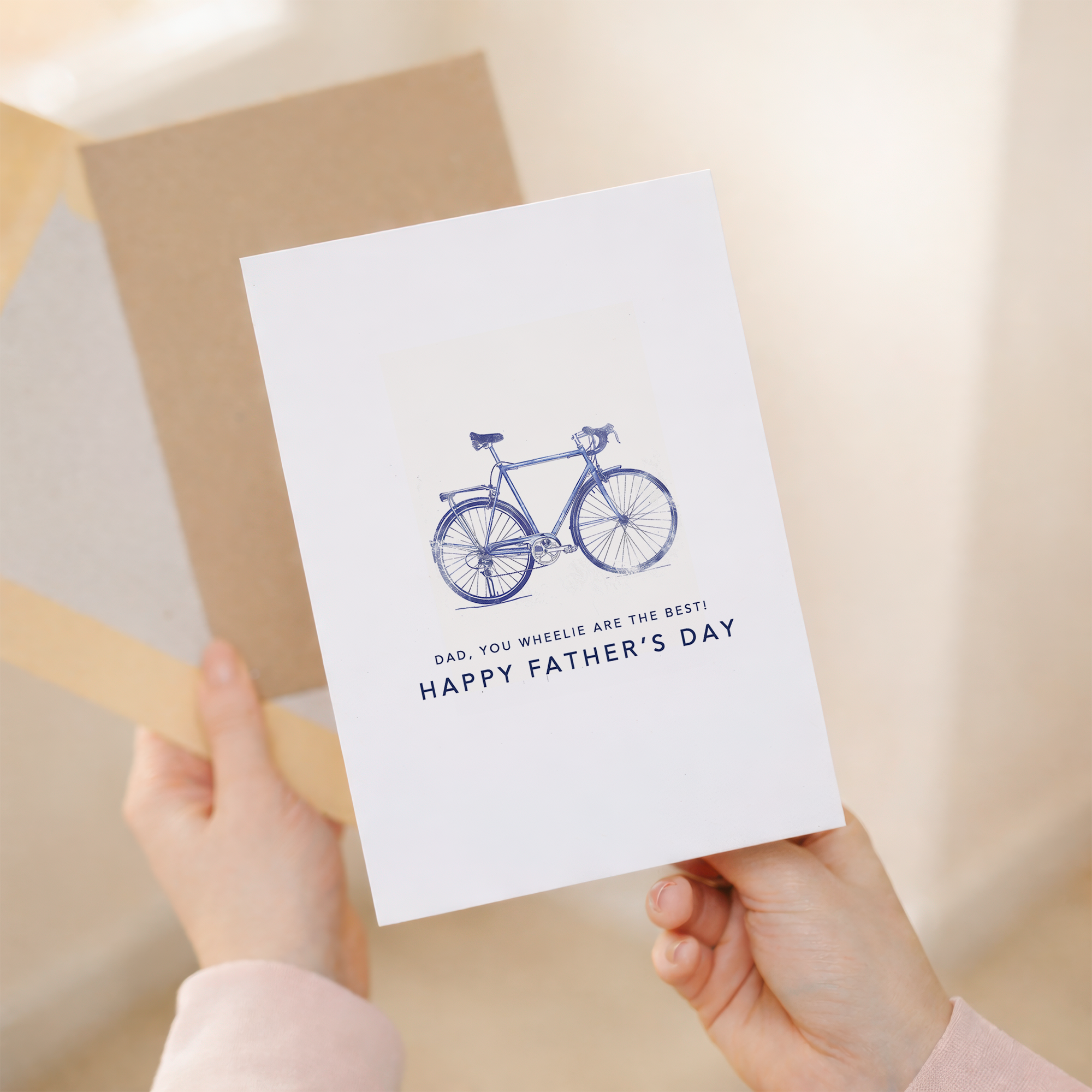Father's Day greeting card with a minimalist blue bicycle illustration and the pun You wheelie are the best dad.