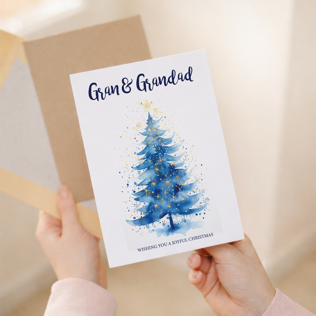 A festive Christmas greeting card featuring a decorated green Christmas tree with a gold star on top, set against a clean white background with a brown kraft envelope.