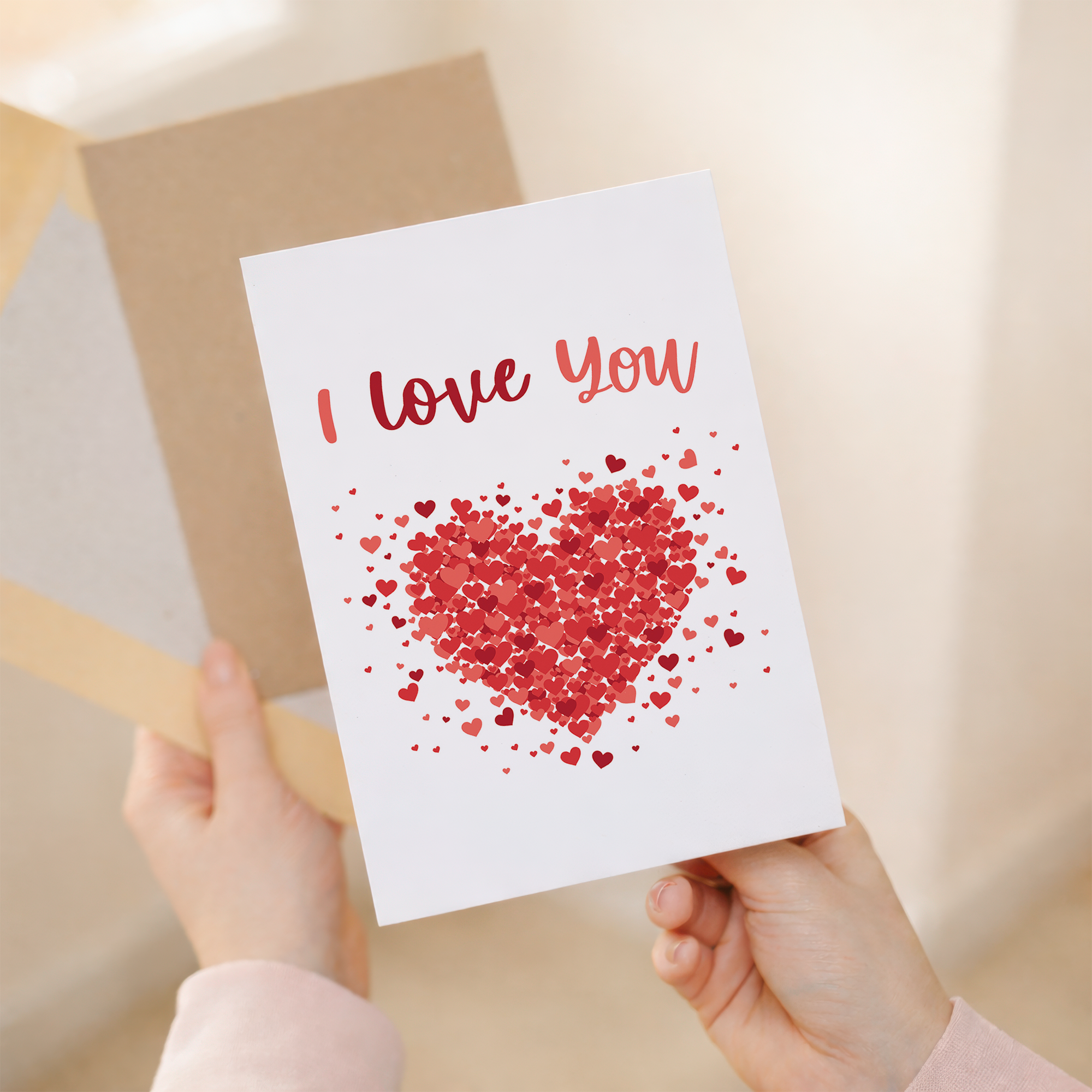 Anniversary card with a minimalist design featuring a pink heart and two smaller red hearts on a white background.