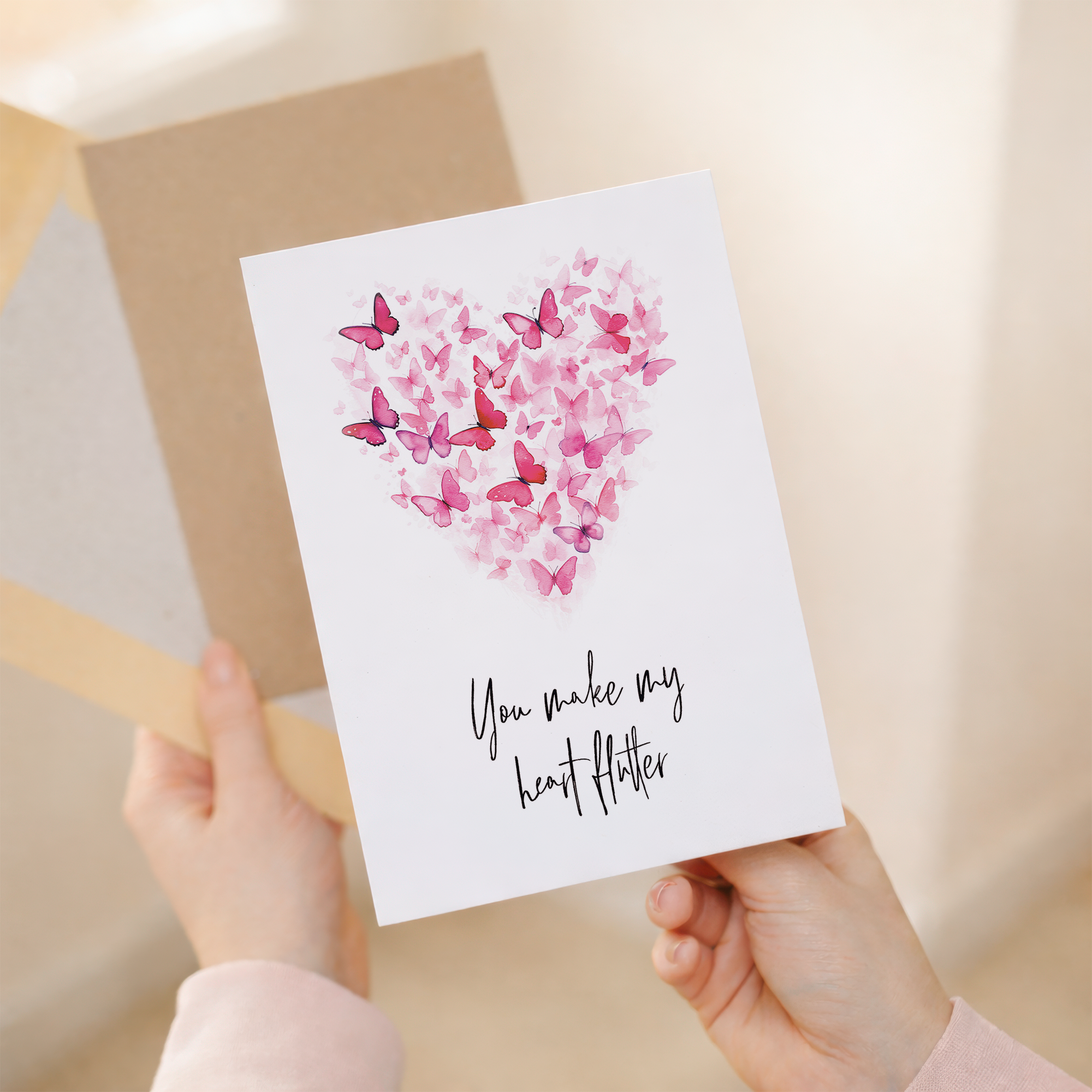 Anniversary greeting card featuring a delicate heart shape composed of various pink, white, and black butterflies on a clean background.