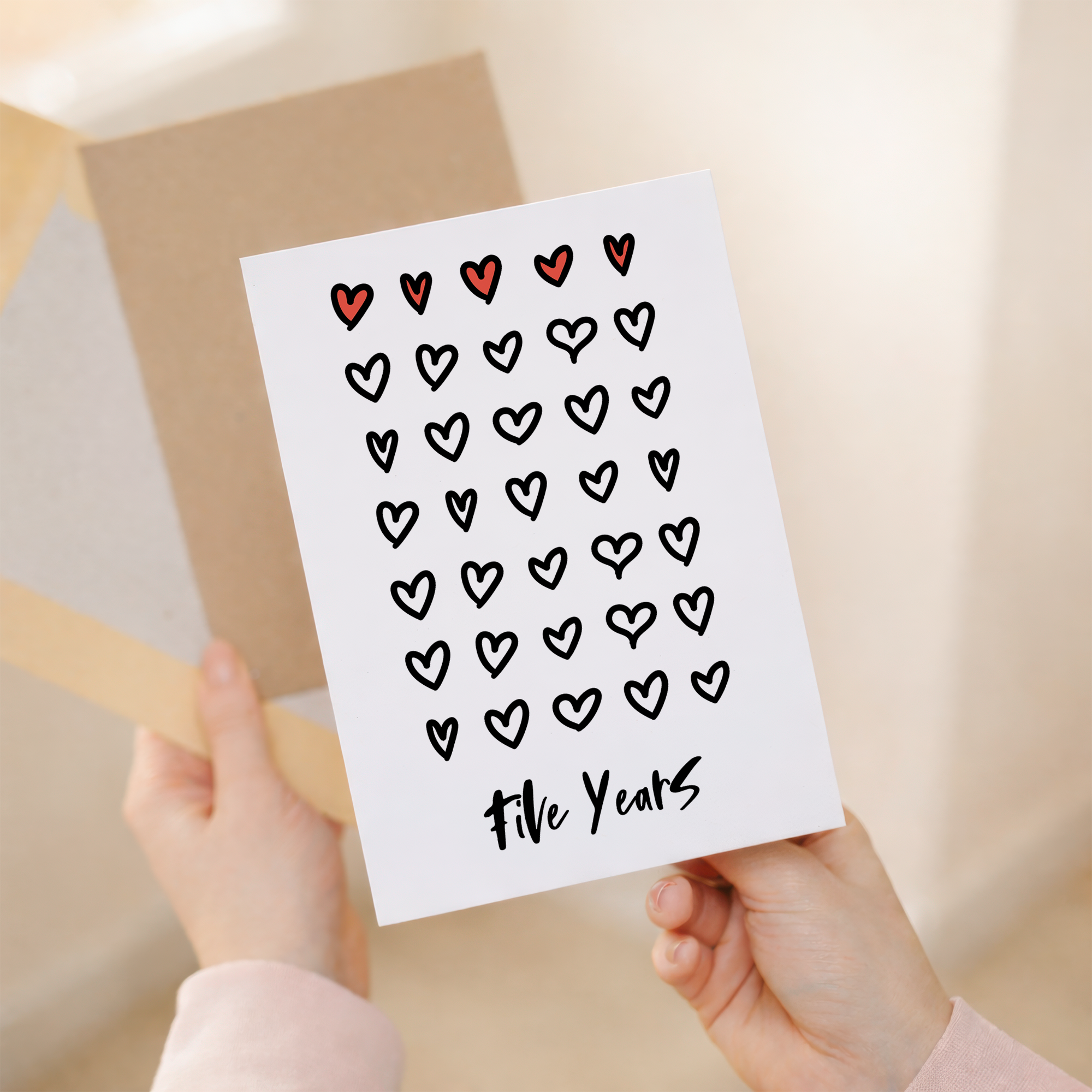 Elegant 5th wedding anniversary greeting card featuring a minimalist design on sustainable recycled cardstock, accompanied by a rustic brown Kraft envelope.