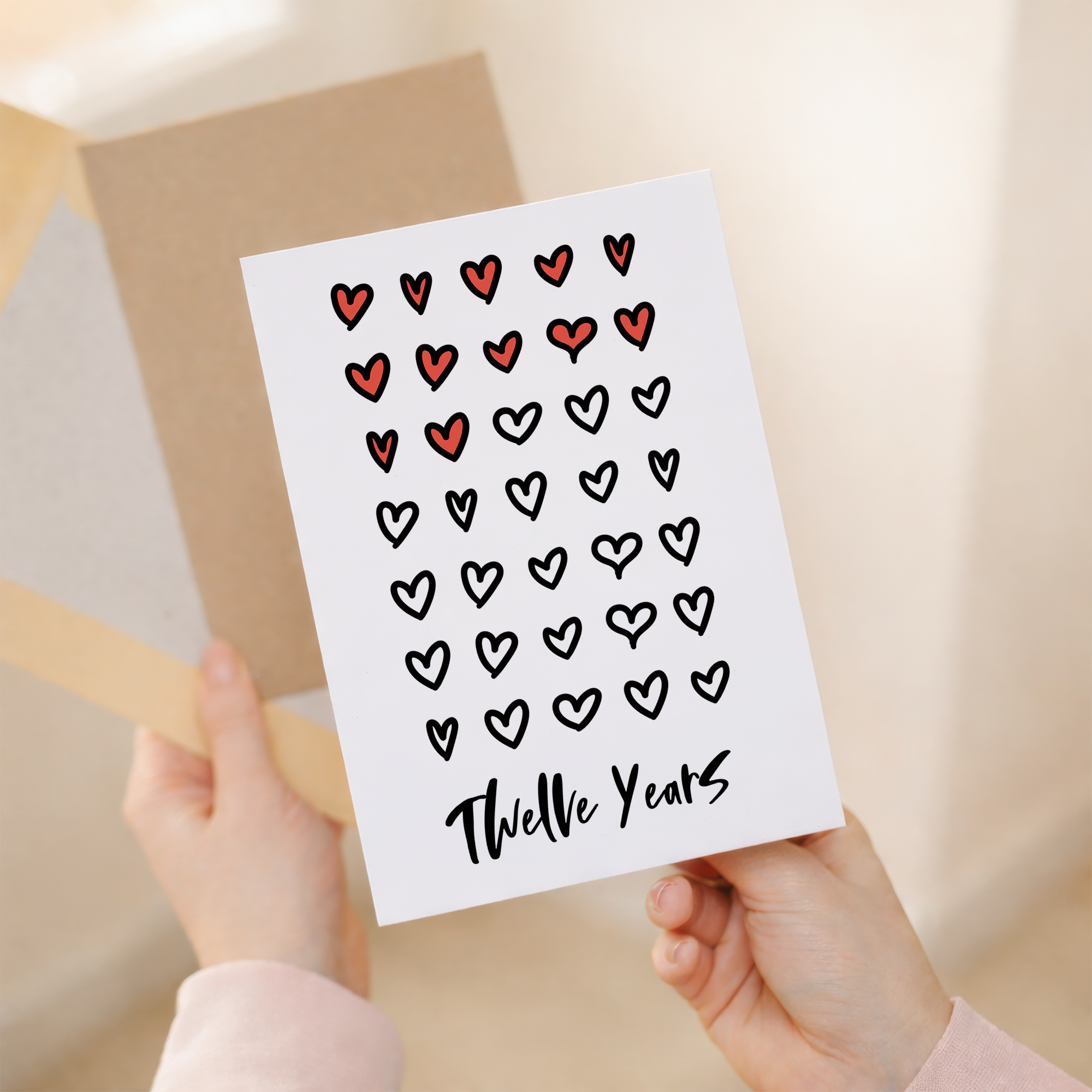Elegant 12th Wedding Anniversary greeting card for a spouse or partner featuring a minimalist design on eco-friendly recycled cardstock, accompanied by a rustic brown Kraft envelope.