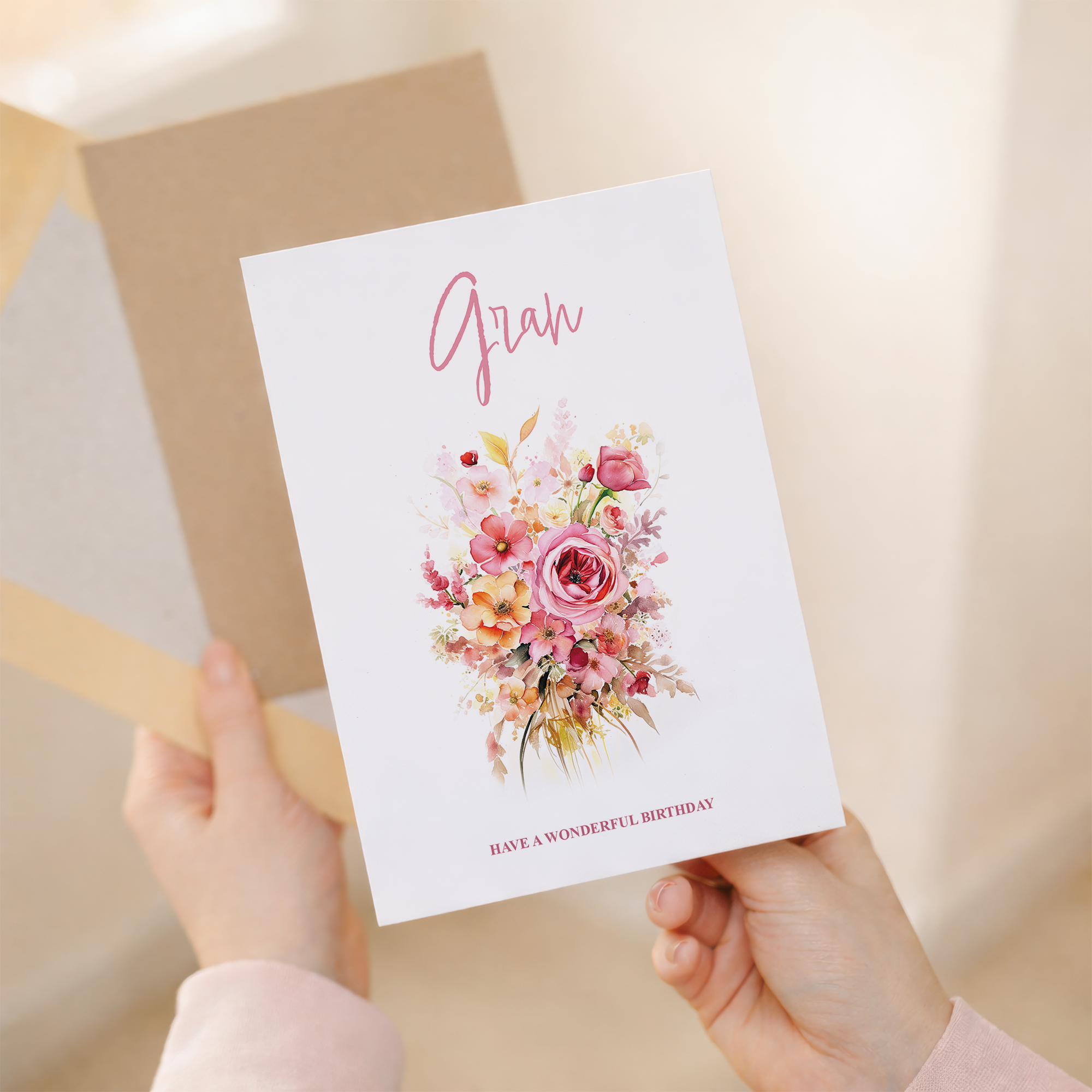 A portrait-oriented greeting card featuring a delicate pink and white floral watercolor design on a white background, with a kraft paper envelope.