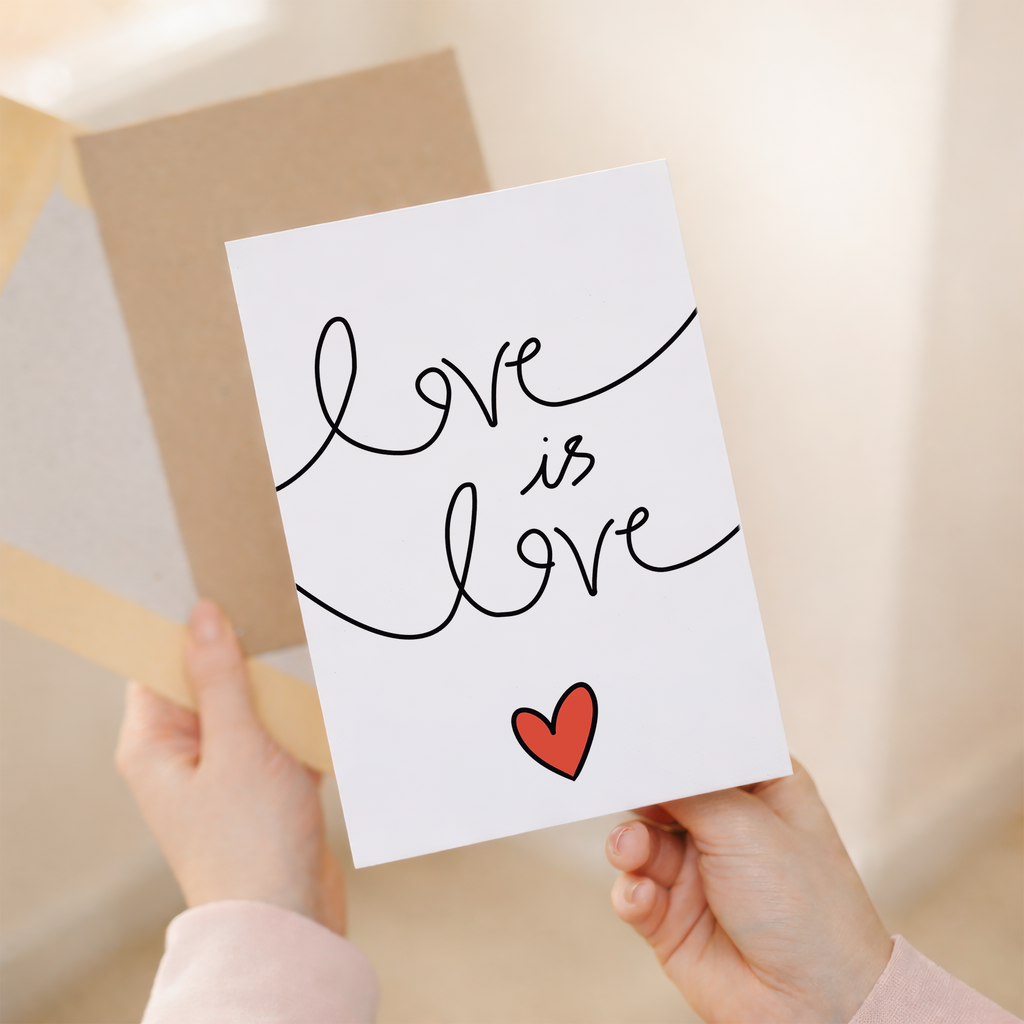 Elegant anniversary greeting card featuring colorful "Love is Love" script text surrounded by delicate floral designs and hearts on a white background, paired with a rustic brown Kraft envelope.