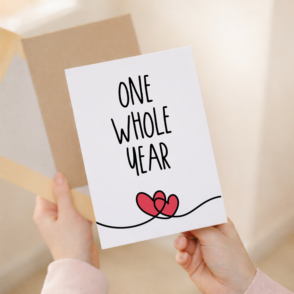Minimalist 1st anniversary greeting card featuring a simple heart and elegant typography on eco-friendly cardstock, accompanied by a rustic brown Kraft envelope.