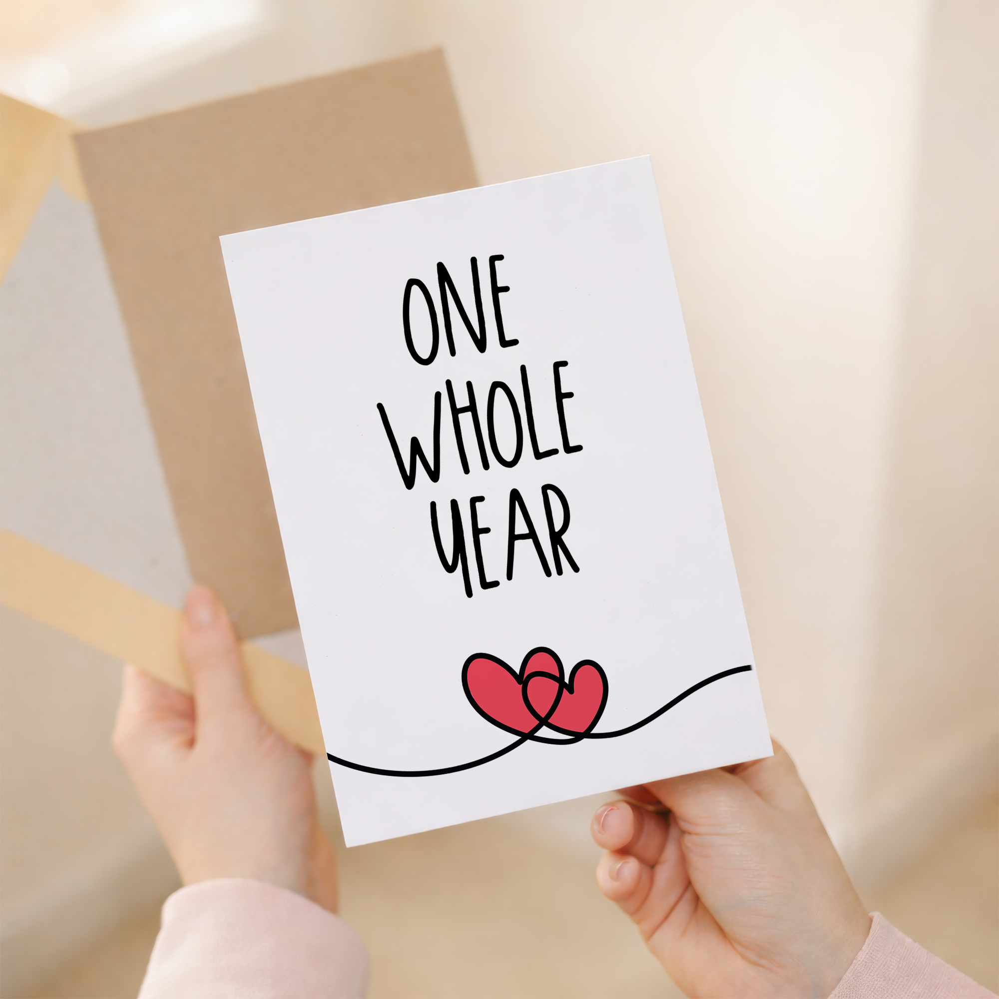 Minimalist 1st anniversary greeting card featuring a simple heart and elegant typography on eco-friendly cardstock, accompanied by a rustic brown Kraft envelope.