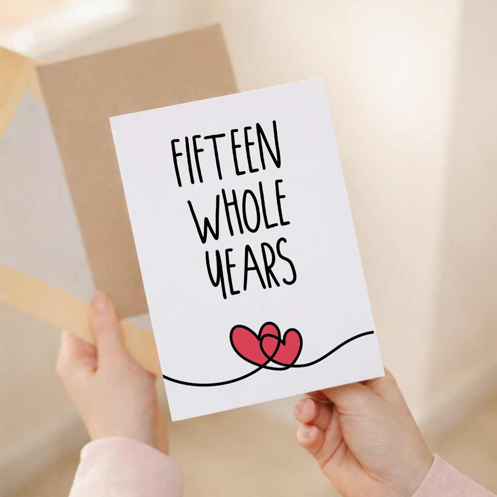 Elegant 15th anniversary greeting card featuring a minimalist heart design on sustainable recycled cardstock, accompanied by a rustic brown Kraft envelope.