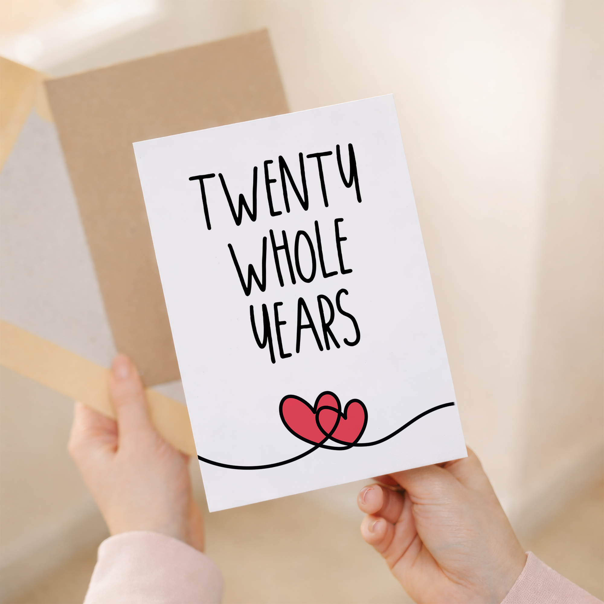 Elegant 20th anniversary greeting card featuring a central "20" design on sustainable recycled cardstock, paired with a rustic brown Kraft envelope.