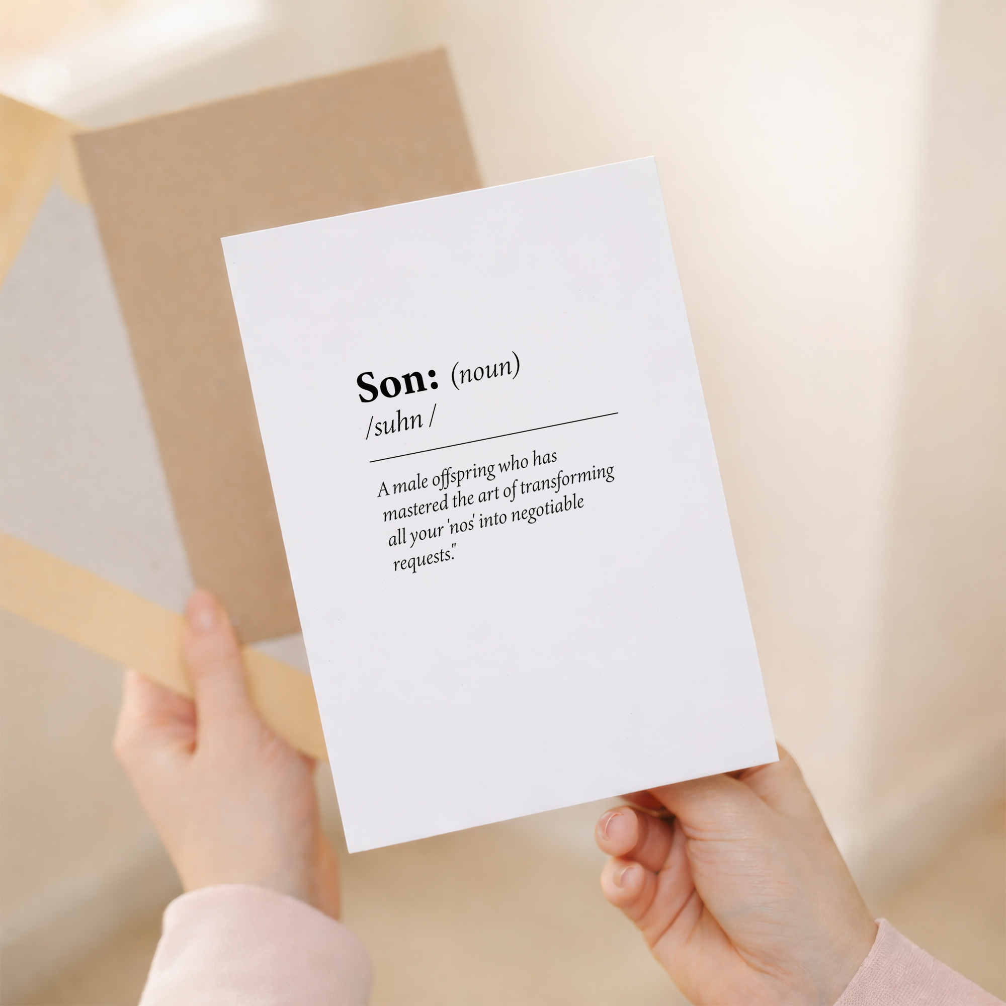 Fun dictionary-style birthday card for a son featuring a humorous definition of the word Son on sustainable recycled cardstock, paired with a brown Kraft envelope.