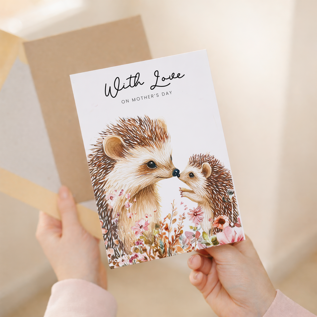 A cute watercolor illustration of a hedgehog on an elegant Mother's Day greeting card, featuring a floral theme with shades of brown, beige, and green.