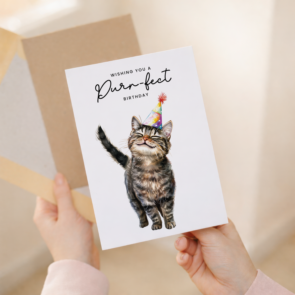 Illustration of a cute brown tabby cat wearing a colorful party hat on a white birthday greeting card.