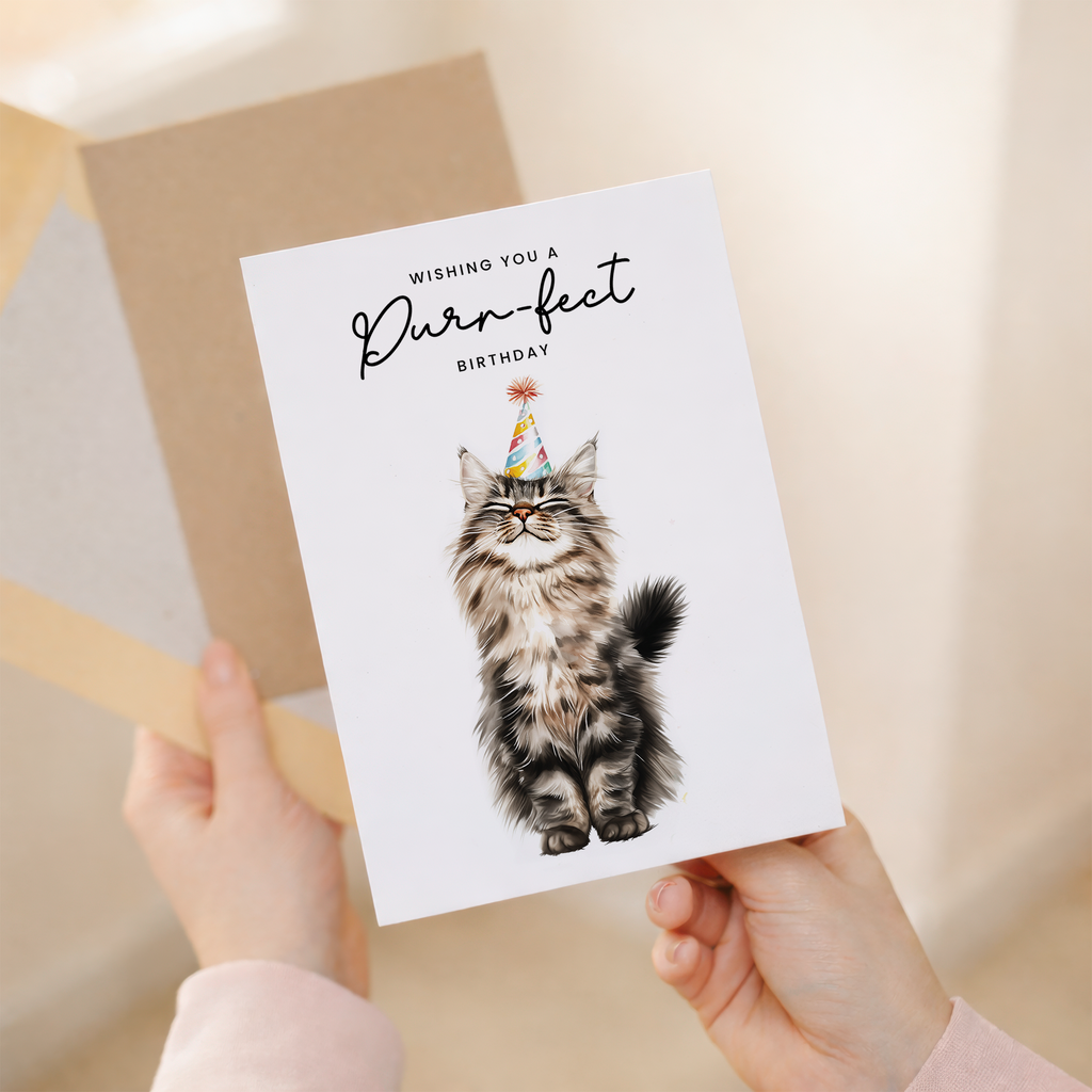 A fluffy Maine Coon cat wearing a colorful party hat on a minimalist birthday greeting card.