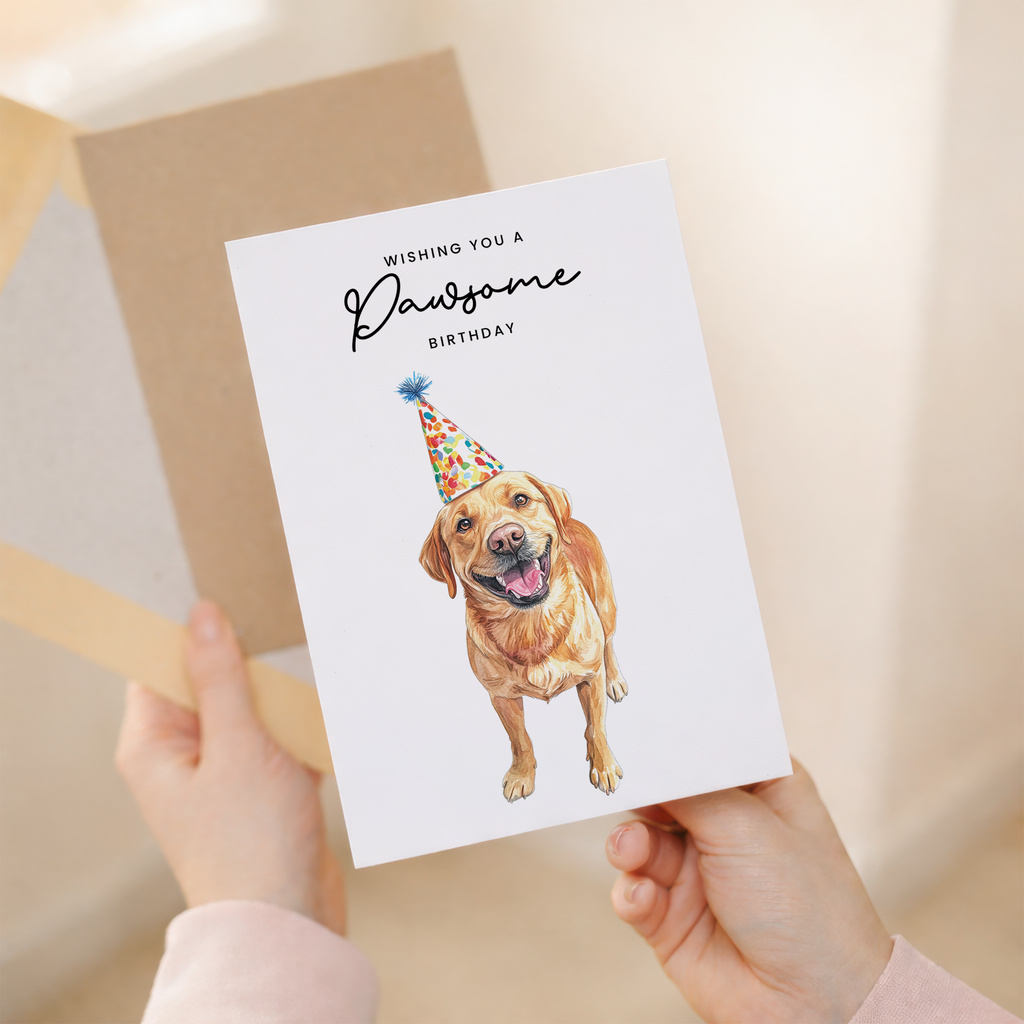 A happy yellow labrador retriever wearing a colorful, striped party hat, featured on a 5x7 inch birthday greeting card with the caption Wishing You a Pawsome Birthday.