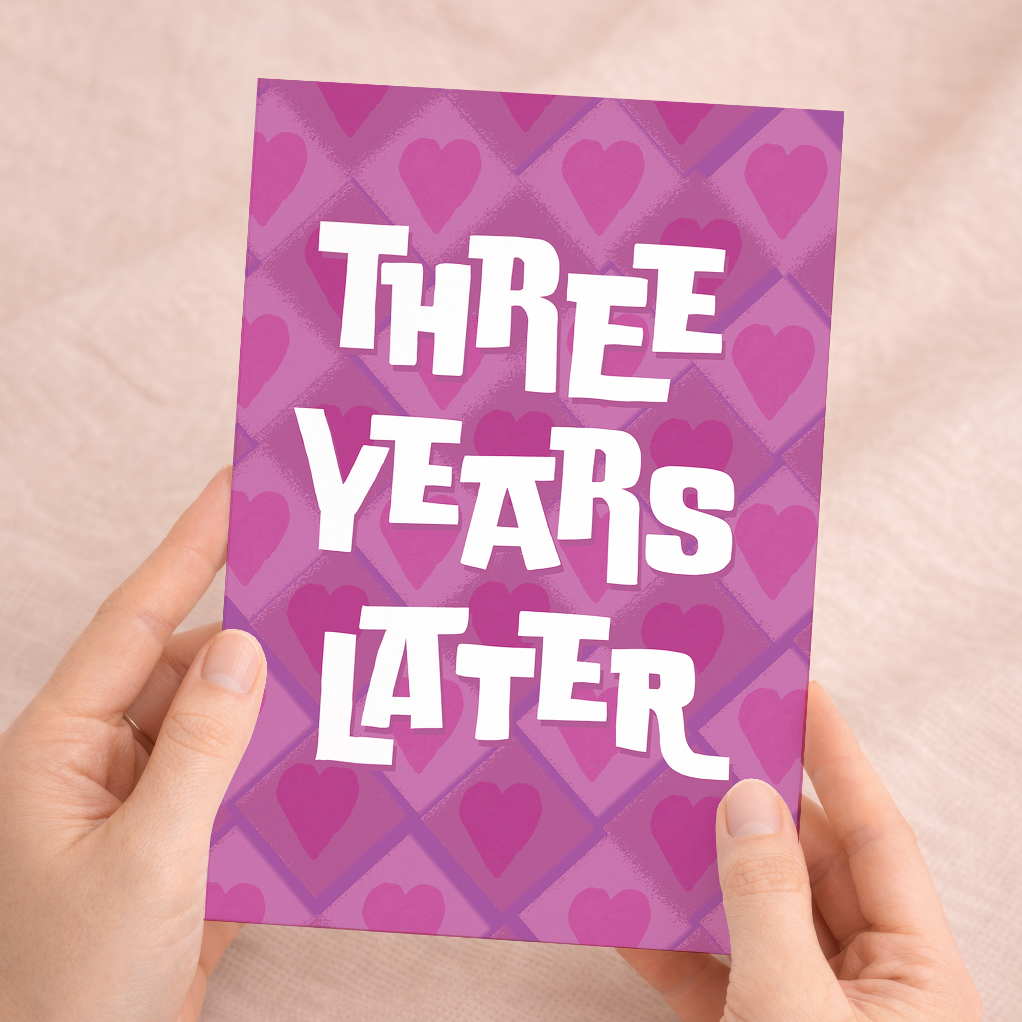 Minimalist 3rd wedding anniversary greeting card featuring the number three in a clean, modern font with pink and purple floral accents on white recycled cardstock, accompanied by a brown Kraft envelope.