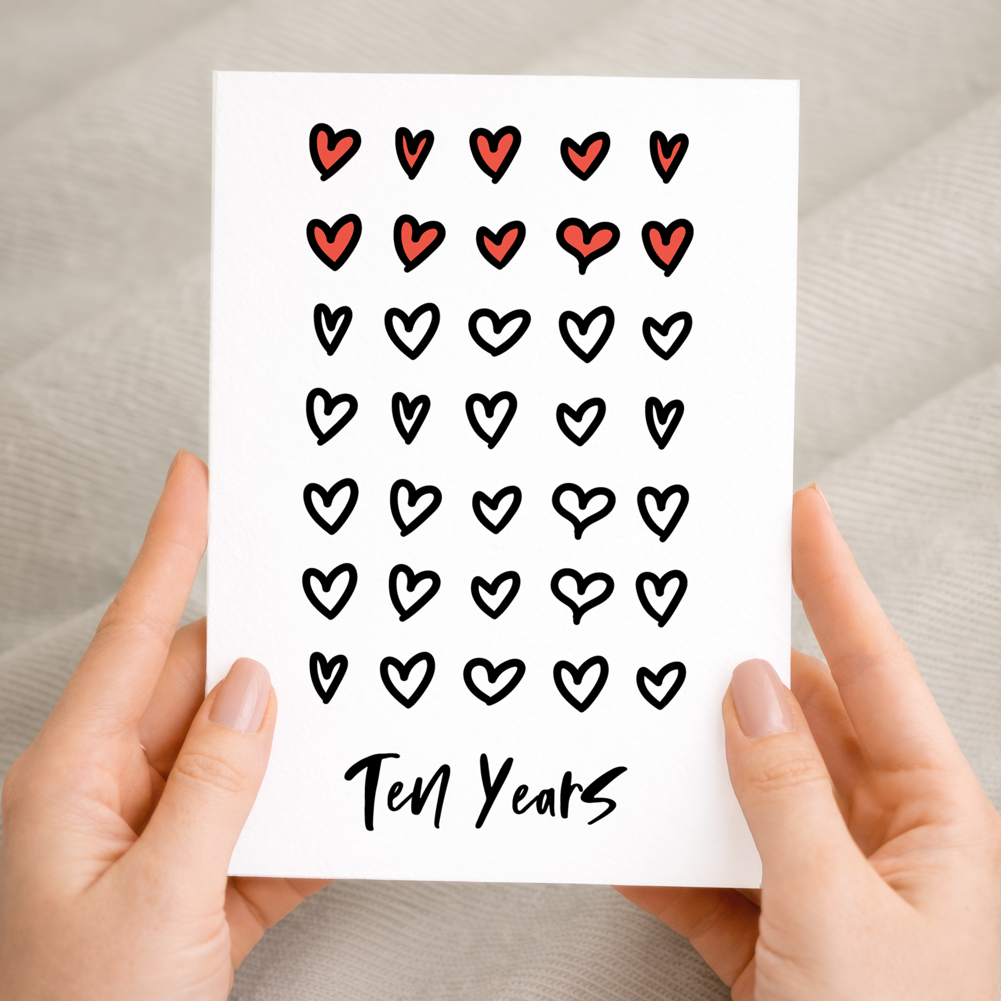 Elegant 10th Wedding Anniversary greeting card with a minimalist design on recycled cardstock, accompanied by a rustic brown Kraft envelope.