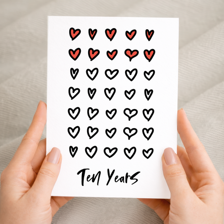 Elegant 10th Wedding Anniversary greeting card with a minimalist design on recycled cardstock, accompanied by a rustic brown Kraft envelope.