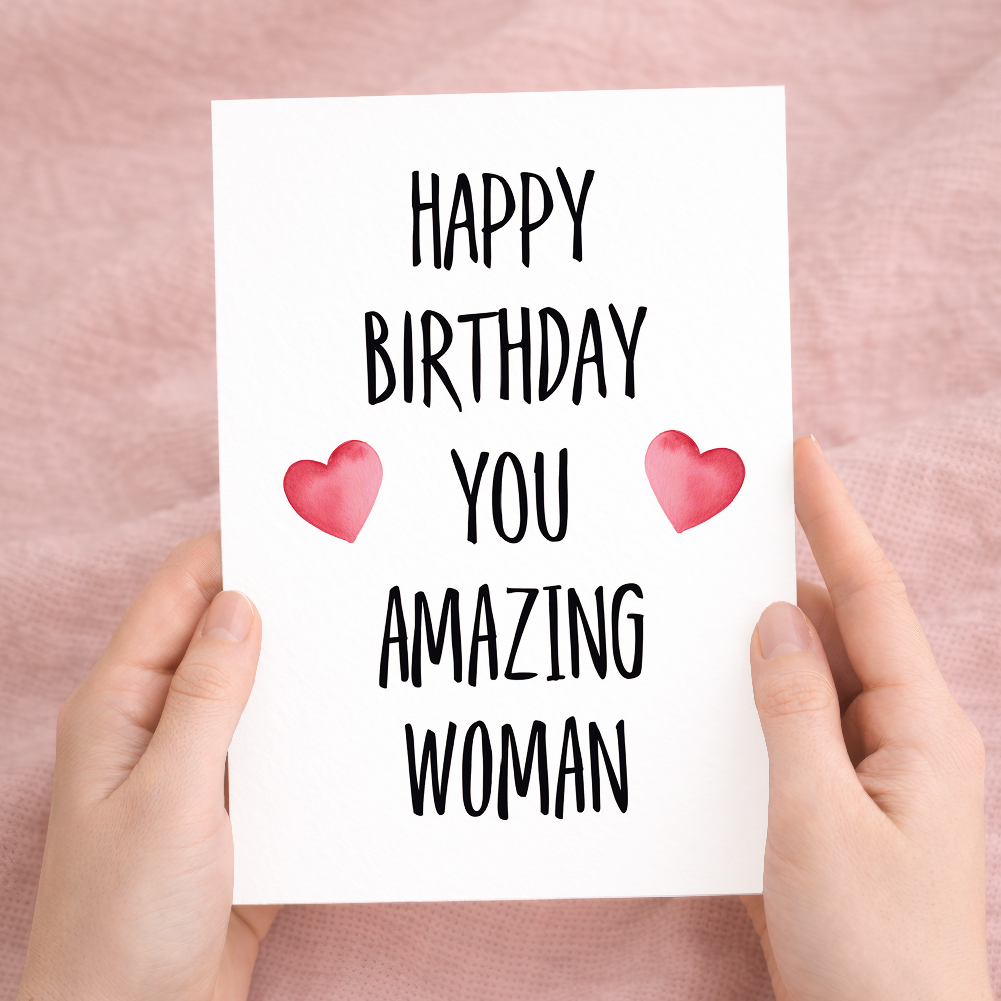 A vibrant birthday greeting card featuring the message "You Amazing Woman" in bold, colorful lettering surrounded by delicate floral illustrations on eco-friendly cardstock, accompanied by a brown Kraft envelope.