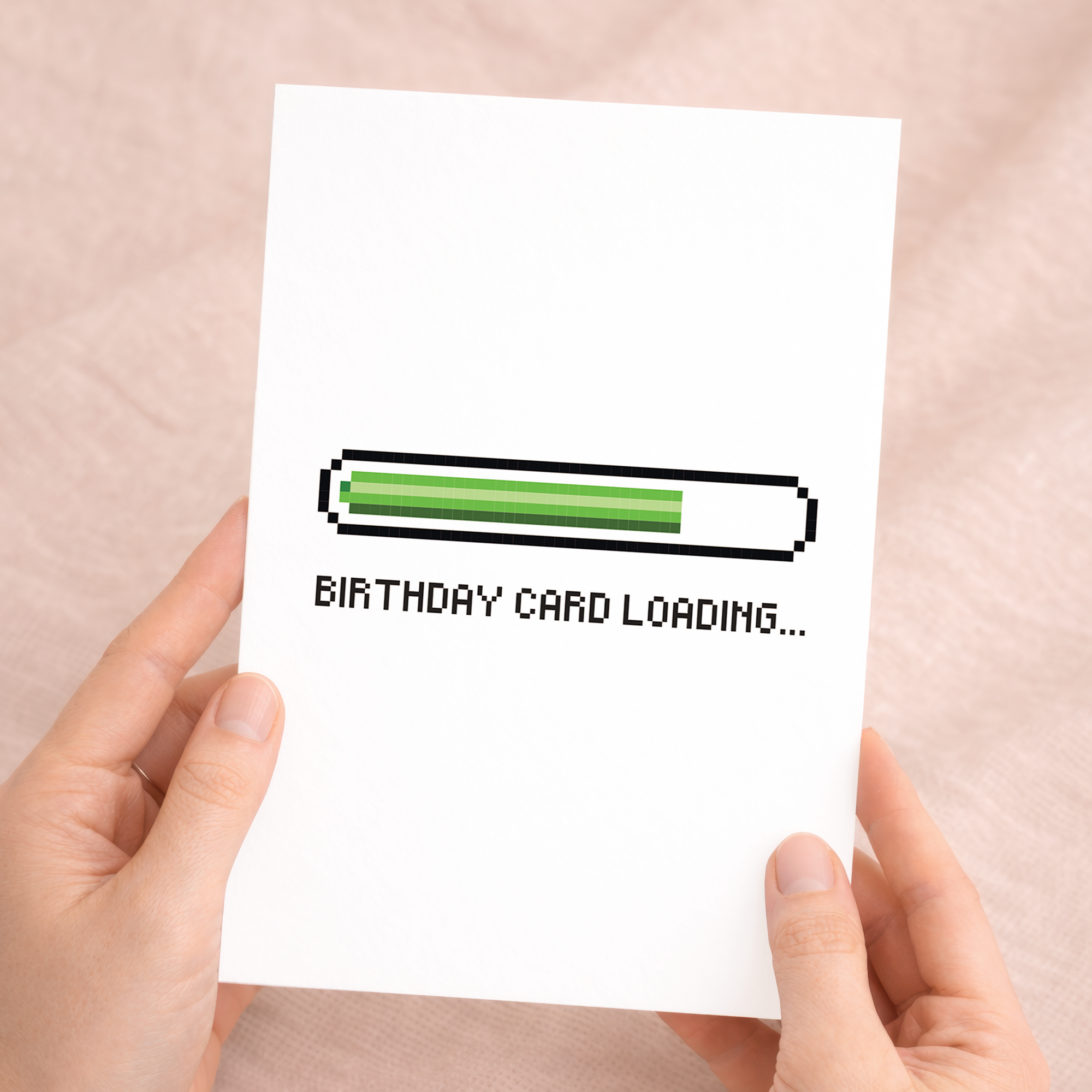 Vibrant birthday greeting card for a gamer featuring a colorful illustration of a handheld game console surrounded by stars and lightning bolts on sustainable cardstock, paired with a brown Kraft envelope.