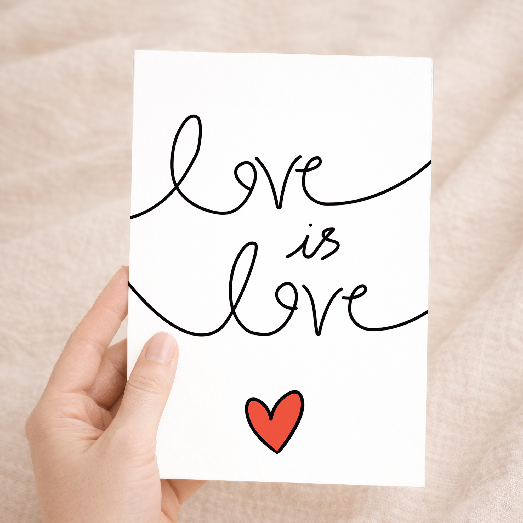 Elegant anniversary greeting card featuring colorful "Love is Love" script text surrounded by delicate floral designs and hearts on a white background, paired with a rustic brown Kraft envelope.