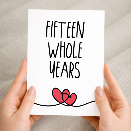 Elegant 15th anniversary greeting card featuring a minimalist heart design on sustainable recycled cardstock, accompanied by a rustic brown Kraft envelope.