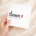A simple and elegant 7th wedding anniversary greeting card for a wife or husband featuring a romantic design with letters and numbers on a white background.