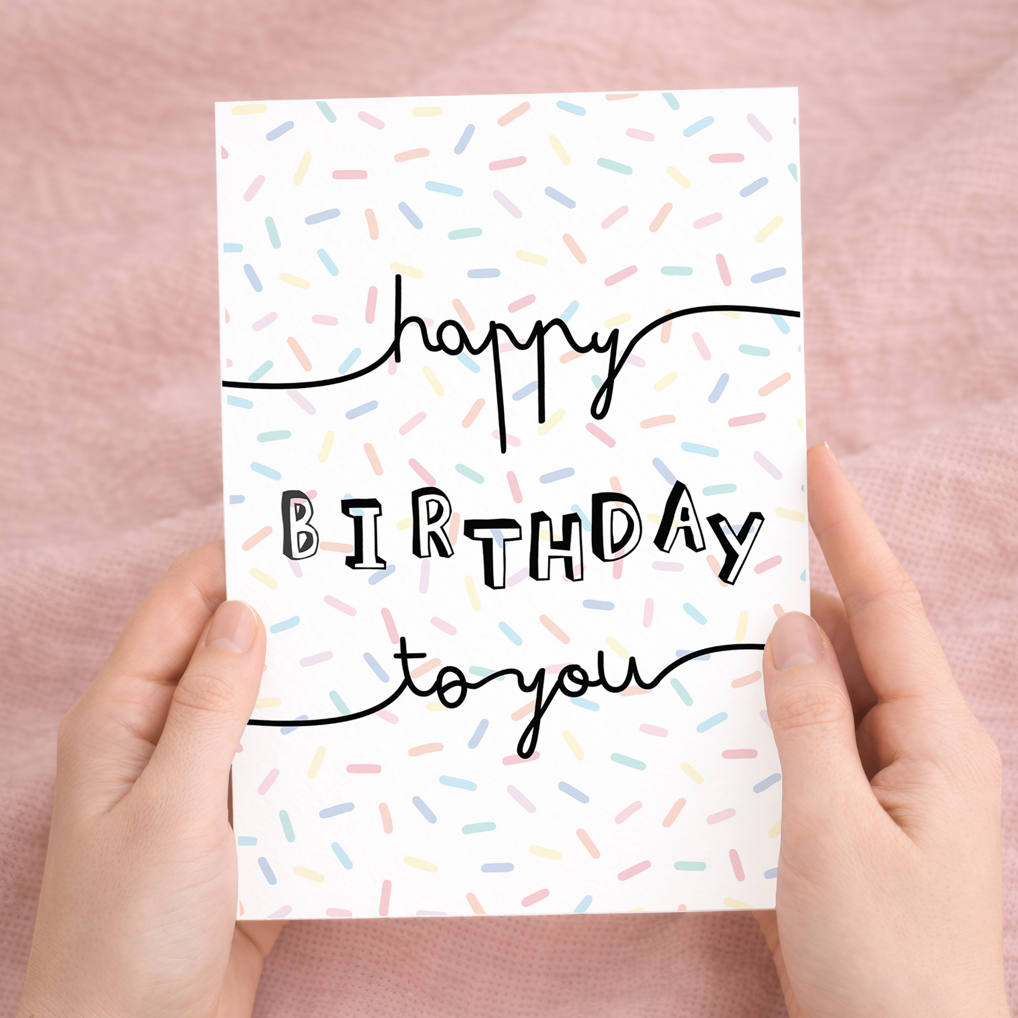 A stylish birthday greeting card featuring a typographic letters and numbers design on sustainable recycled cardstock, paired with a brown Kraft envelope.