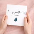 A romantic Christmas greeting card for a girlfriend celebrating their first Christmas together, featuring a stylish typographic design on a white background.