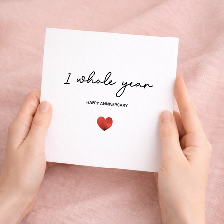 A simple and modern 1st Anniversary greeting card featuring a charming love heart design on a white background.