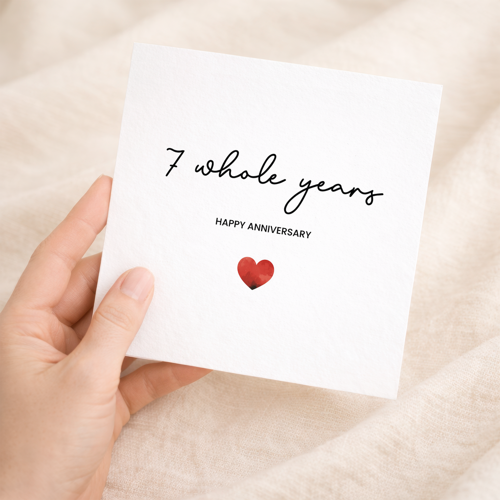A simple and charming 7th anniversary greeting card featuring a modern love heart design on a white background.