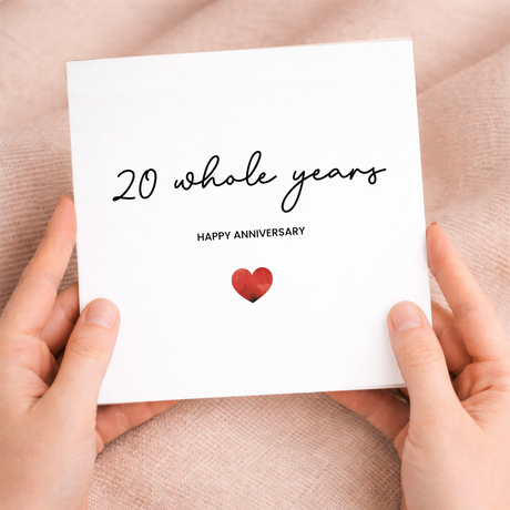 A simple 20th anniversary greeting card featuring a modern red love heart design on a white background, accompanied by a brown kraft envelope.