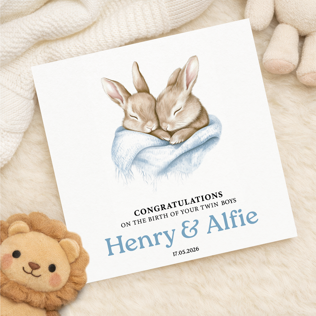 Personalised twin boys new baby card with illustrated bunnies in a blue blanket.