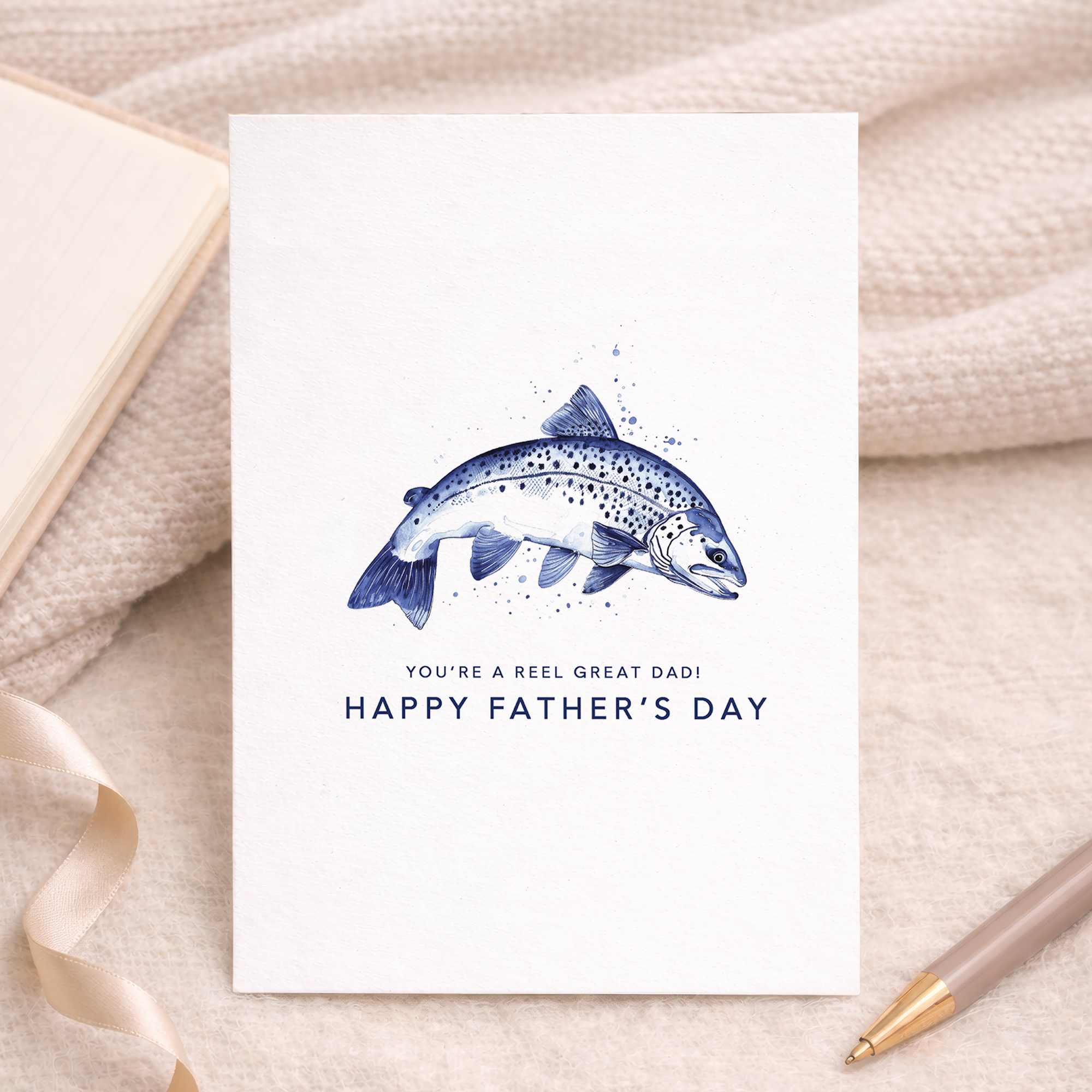 A simple and minimalist Father's Day greeting card featuring a blue fishing hook illustration on a white background with the text You are a reel catch.