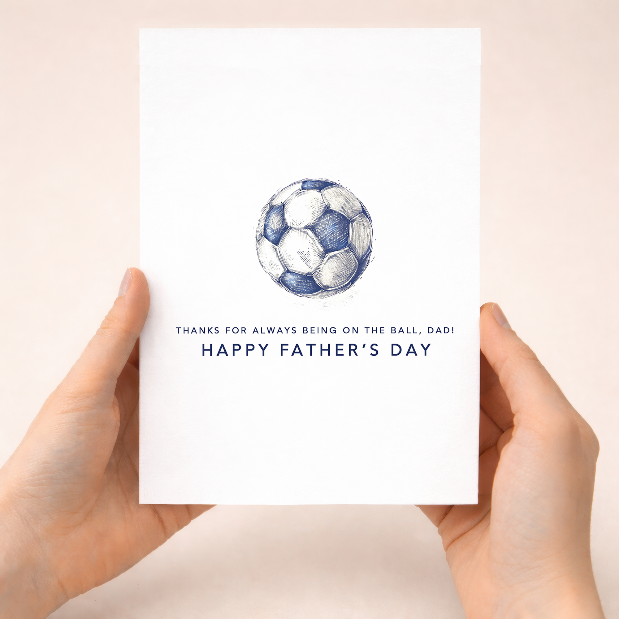 Minimalist Father's Day greeting card featuring a blue and white football with the text "On the ball Dad" on a white background.
