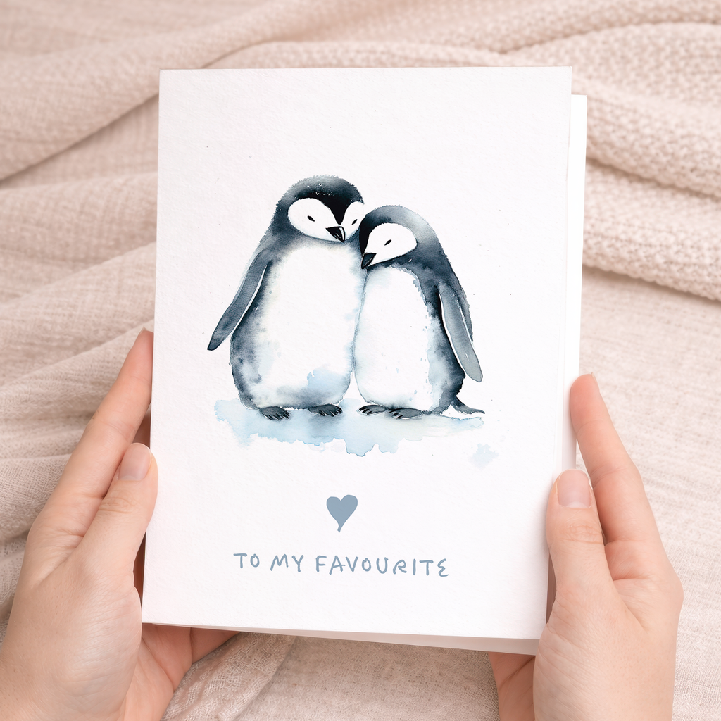 An illustration of two cute penguins standing together with a small red heart between them, on a simple white background.