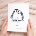 An illustration of two cute penguins standing together with a small red heart between them, on a simple white background.