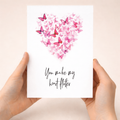 Anniversary greeting card featuring a delicate heart shape composed of various pink, white, and black butterflies on a clean background.