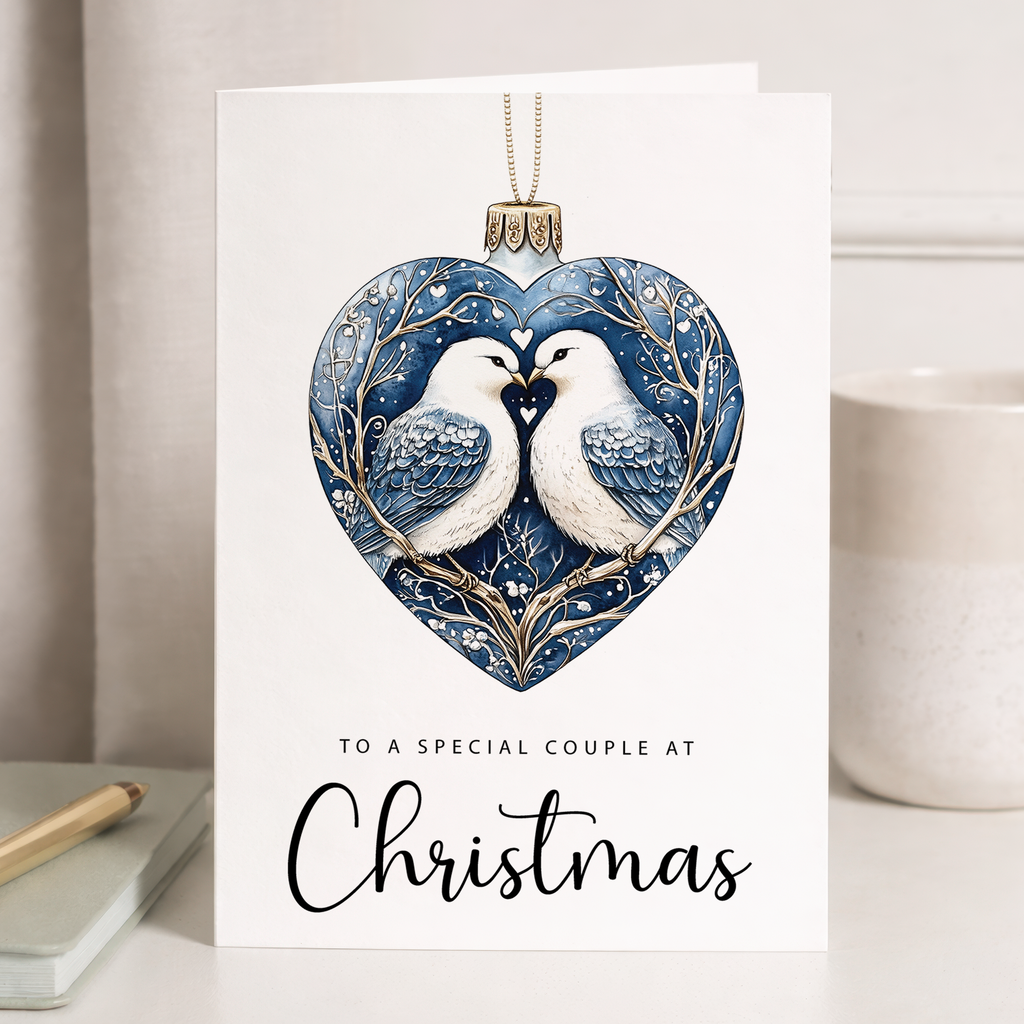 Romantic Christmas card featuring a watercolor illustration of two turtle doves perched on a festive holiday bauble decorated with a red love heart.