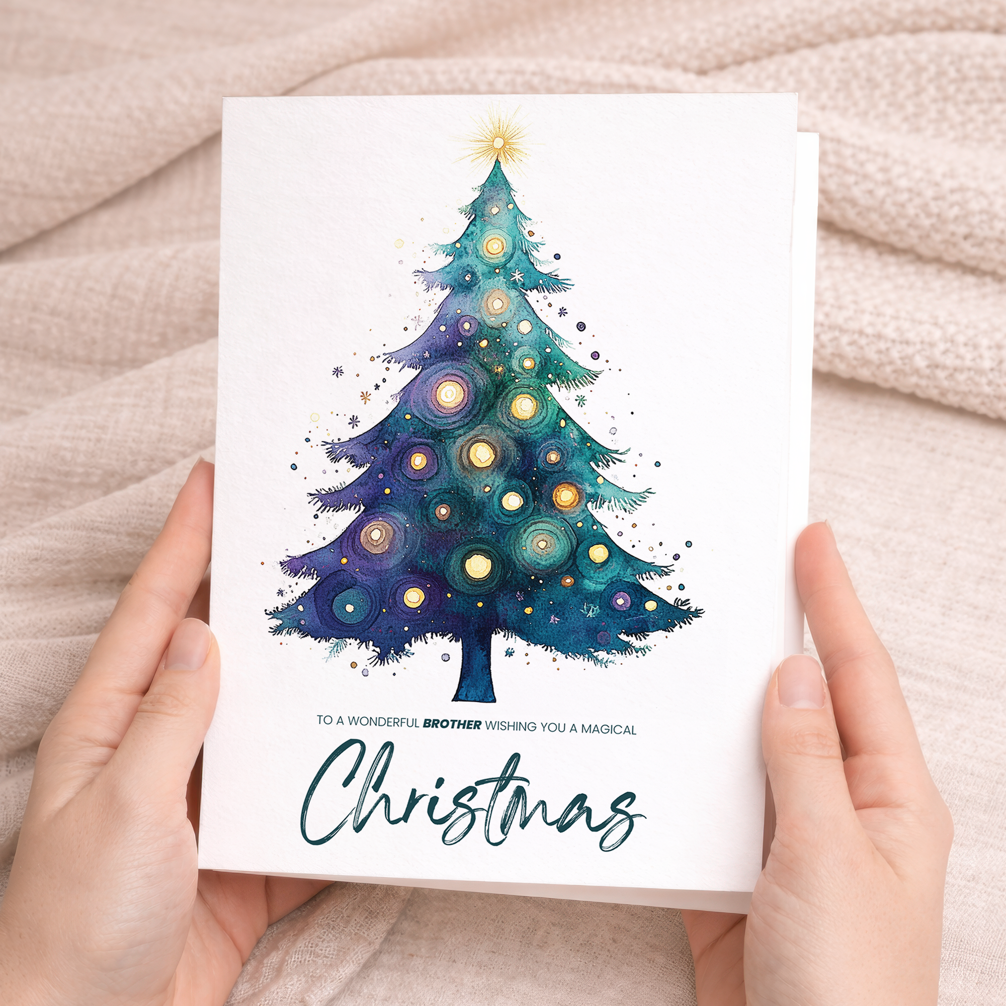 Watercolour illustration of a green Christmas tree decorated with red baubles, resting on a brown kraft envelope.