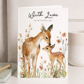 A charming Mother's Day card featuring a cute watercolor illustration of a deer surrounded by delicate floral accents on a clean white background.