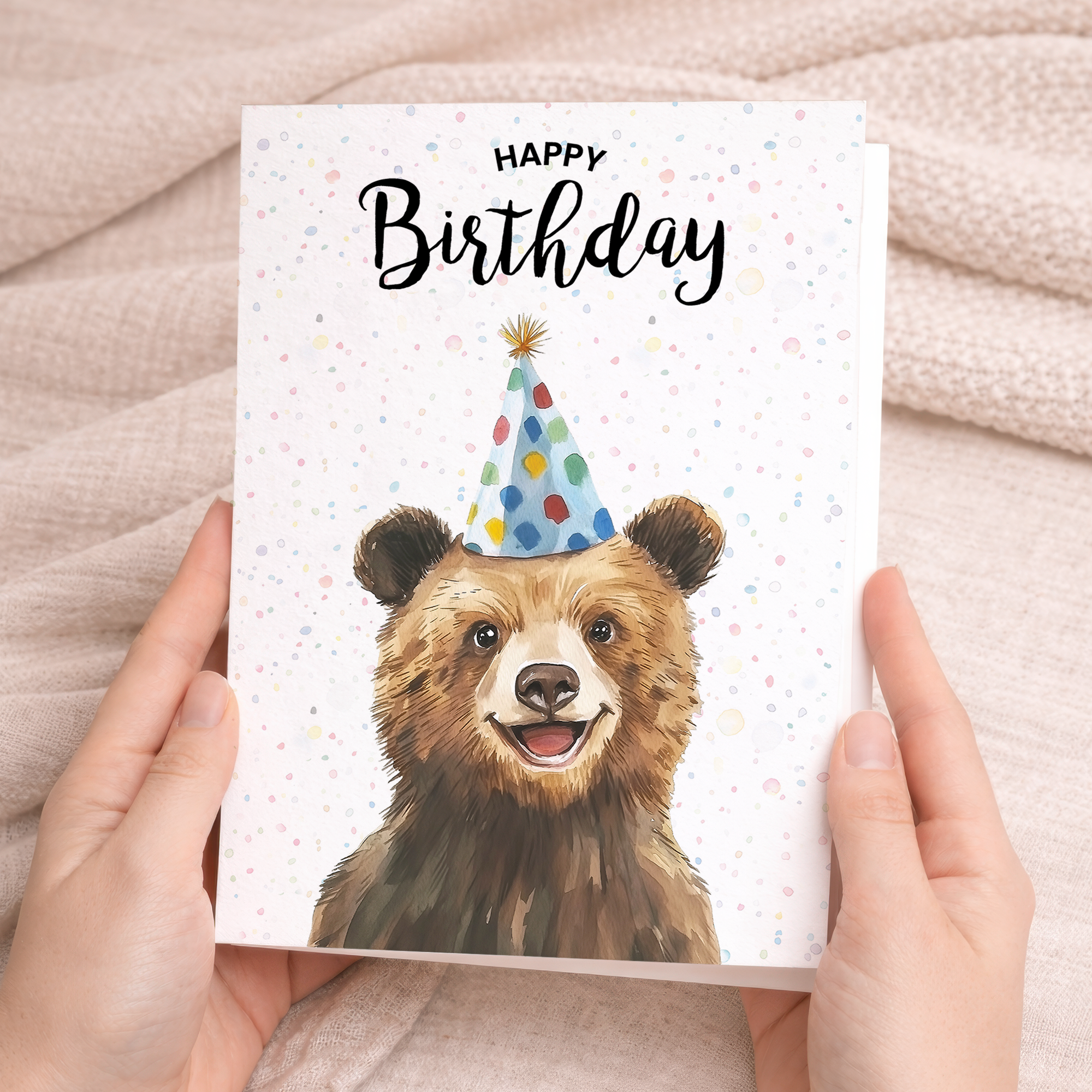 A charming watercolor illustration of a brown bear on a white birthday greeting card.