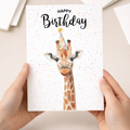 Watercolour illustration of a giraffe on a birthday greeting card.