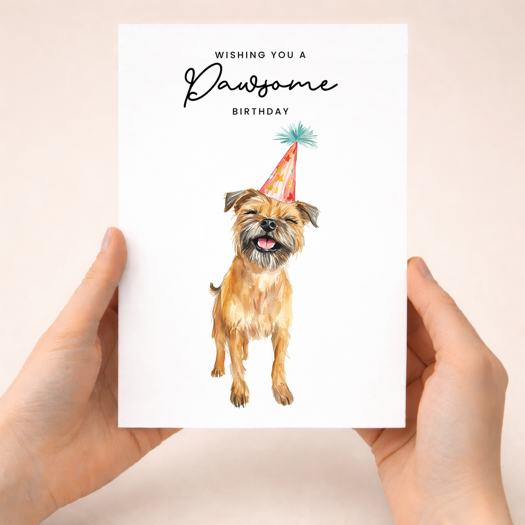 A cute Border Terrier wearing a colorful party hat on a minimalist birthday greeting card with the text Wishing You a Pawsome Birthday.